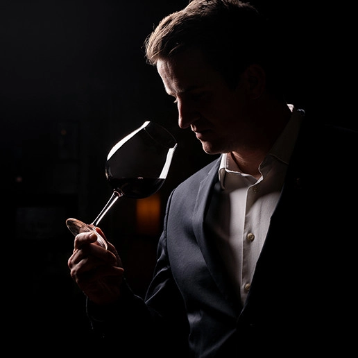 A man smelling a glass of wine at Dans le Noir ? restaurant