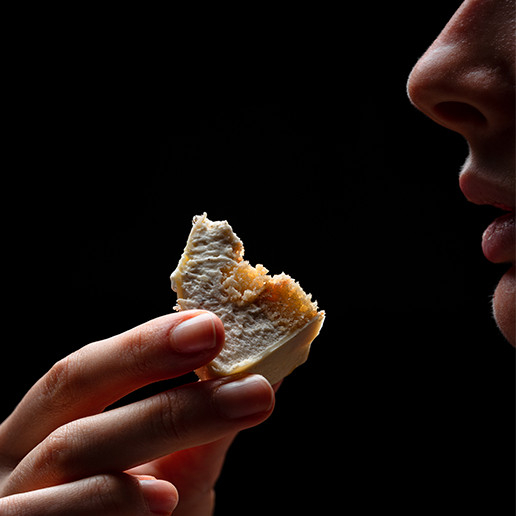 Woman savoring a bite at Dans le Noir ? restaurant