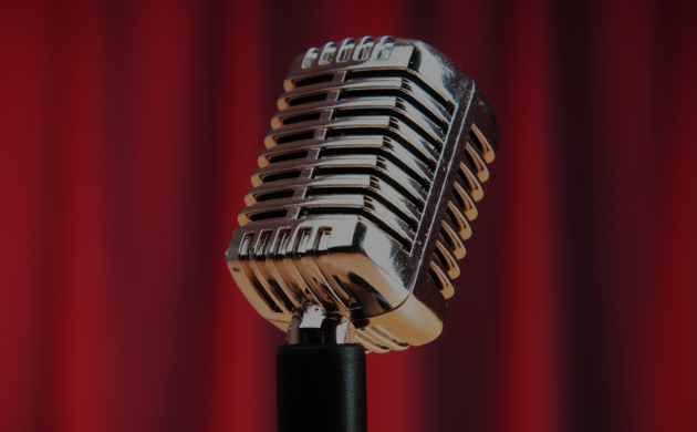 Microphone sur scène de comedy club devant un rideau rouge, prêt pour une soirée de stand up à Marseille